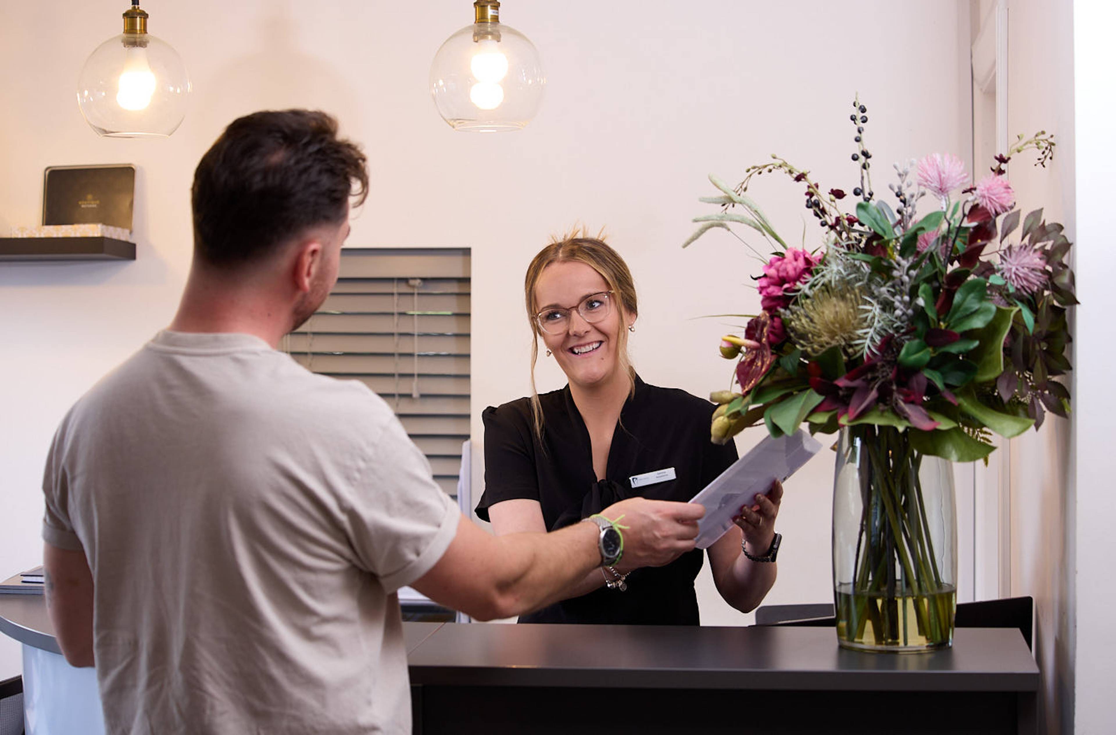Receptionist speaking to patient at Precision Dental Clinic