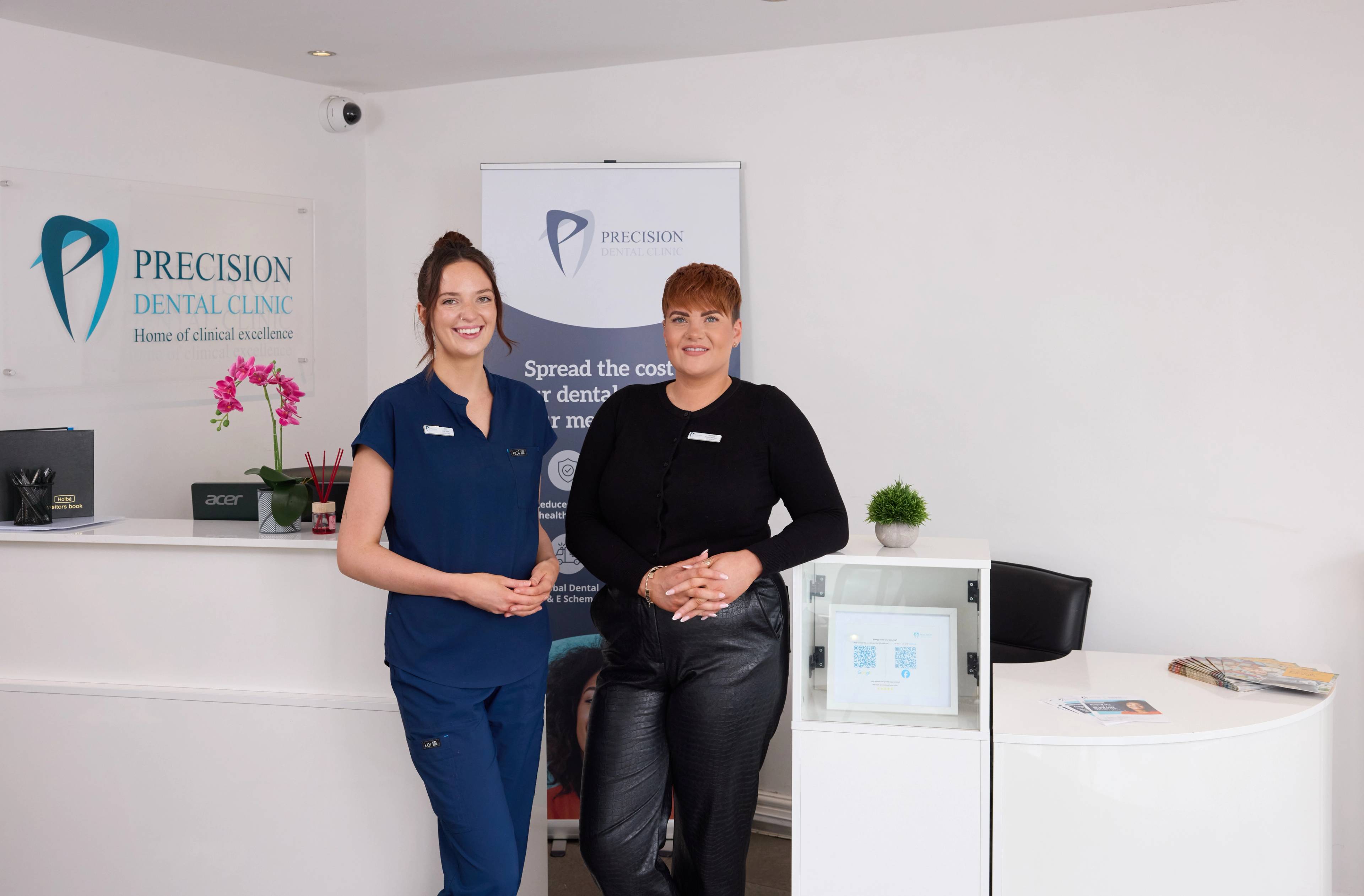 Precision Dental Clinic reception team smiling to welcome patients in for family dental care