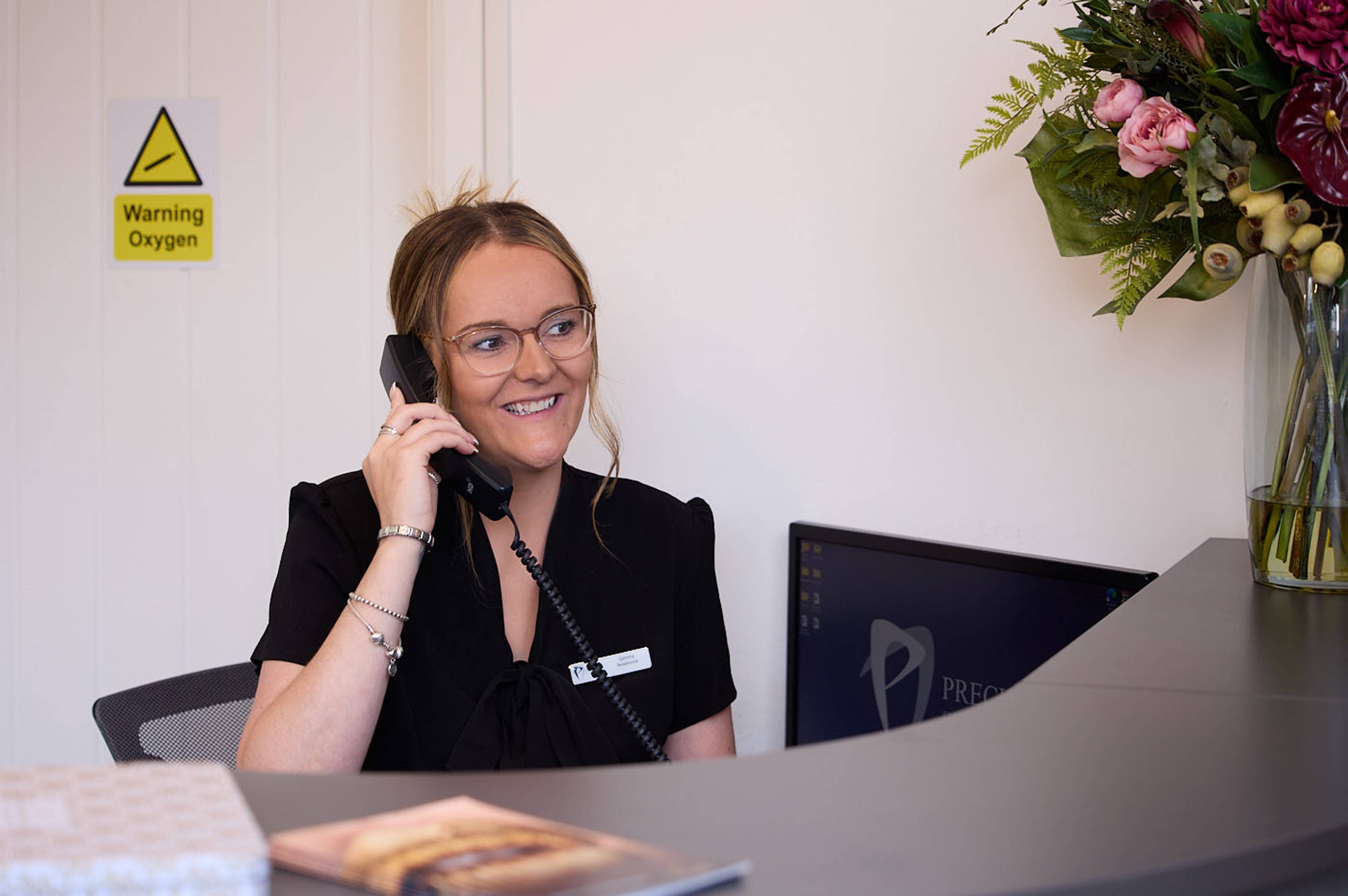 Precision Dental Clinic receptionist talking to patient on the phone about finance options