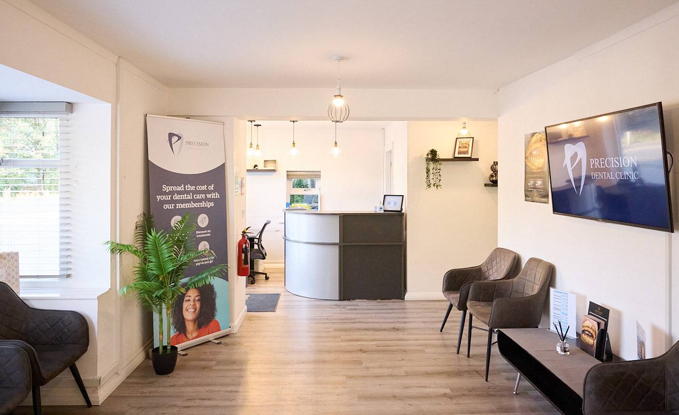 patient waiting area featuring signage chairs and customer help desk with warm lighting in a relaxed environment