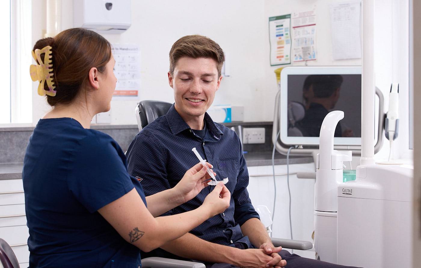 patient being shown teeth whitening treatment by dental nurse in a dental surgery
