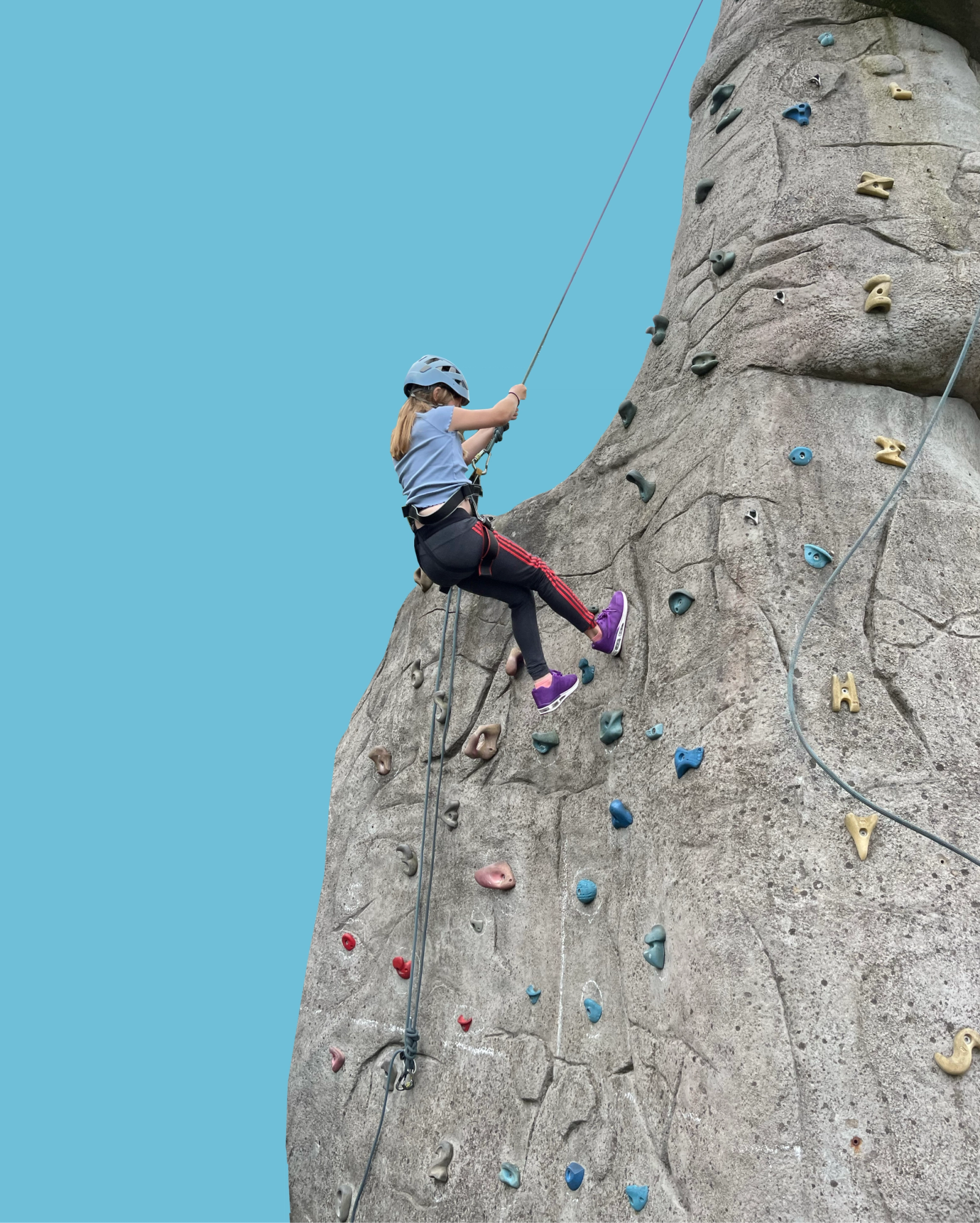 Young girl rock climbing cutout with blue background