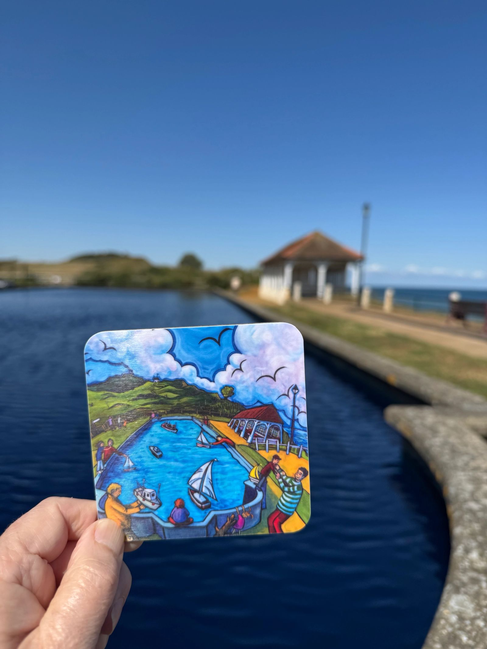 Person holding coaster of painting