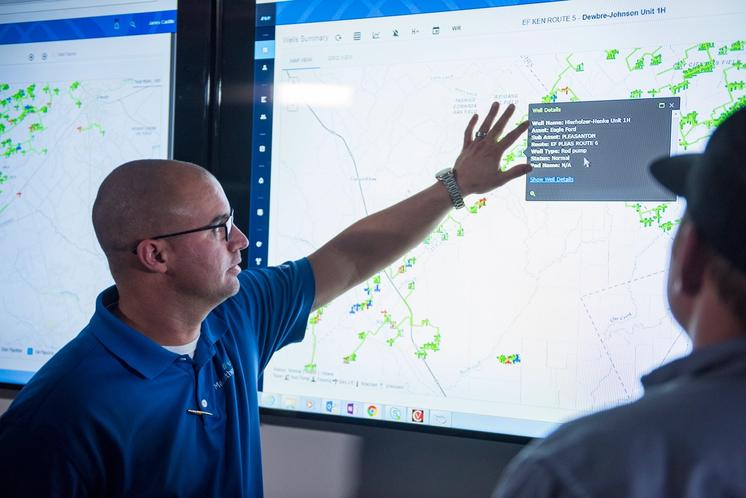 Employees looking at a digital operations map