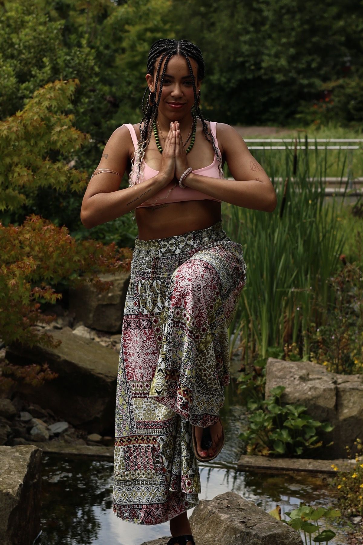 Rebecca Yvonne Koffi in einer Yoga-Haltung in der Natur