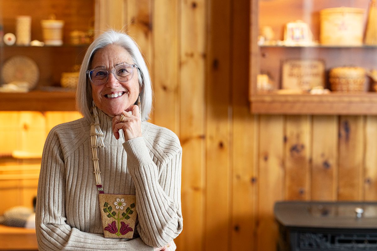 Theresa Secord standing in front of a wall with wooden paneling and baskets on shelves in the background