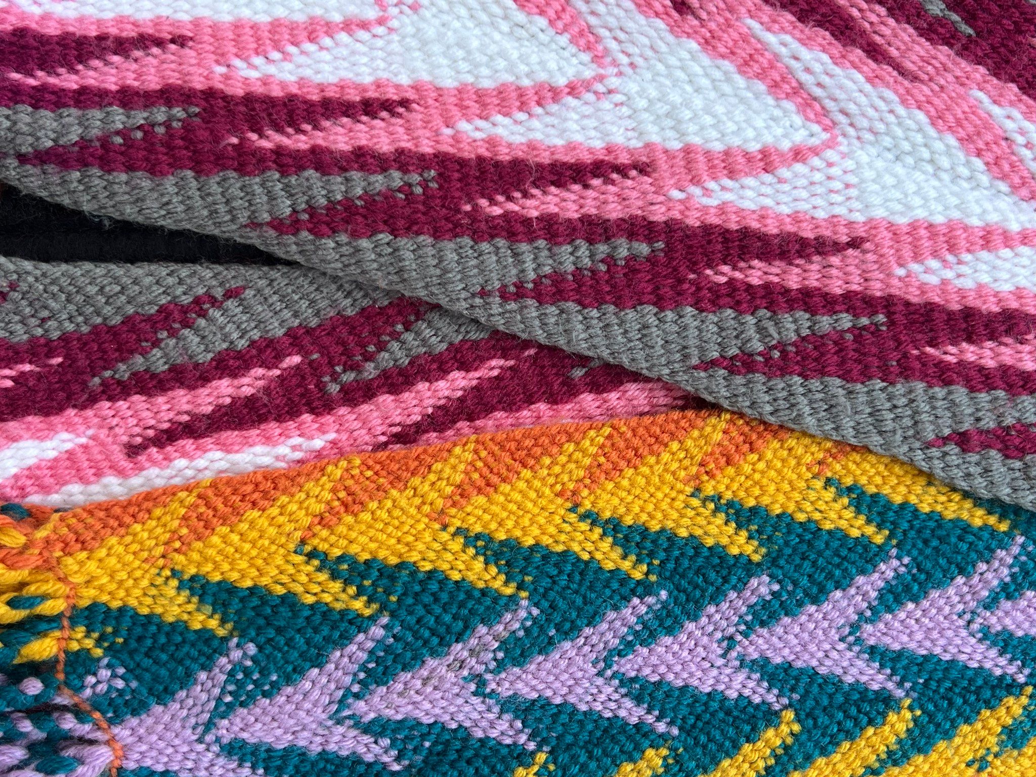 A close up image of colorful, geometric, woven fabric