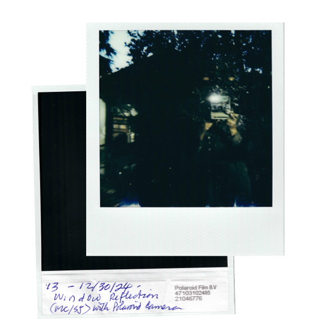 Polaroid photograph of window reflection, featuring Suzanne Jackson photographing with the camera outside of a house and a handwritten note on the reverse that says "13 - 12/30/24 - Window Reflection with Polaroid camera"