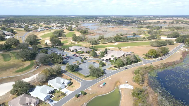 Aerial view of the Royal Highlands clubhouse and homes among water features.