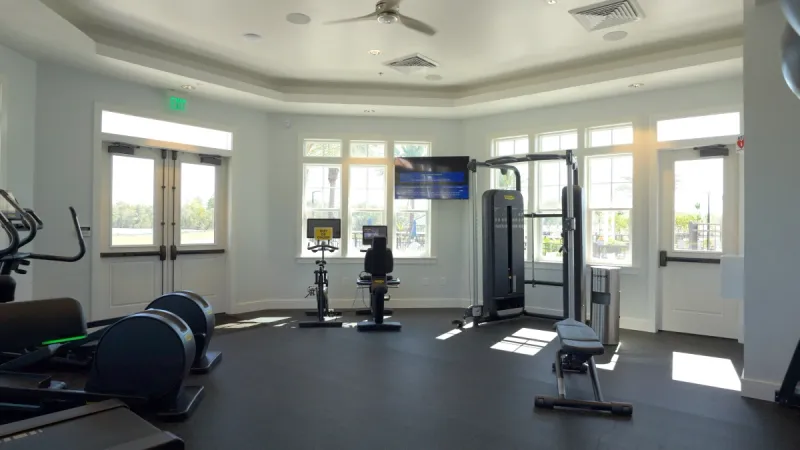 WaterSong at RiverTown gym featuring various types of exercise equipment and large windows letting in light.