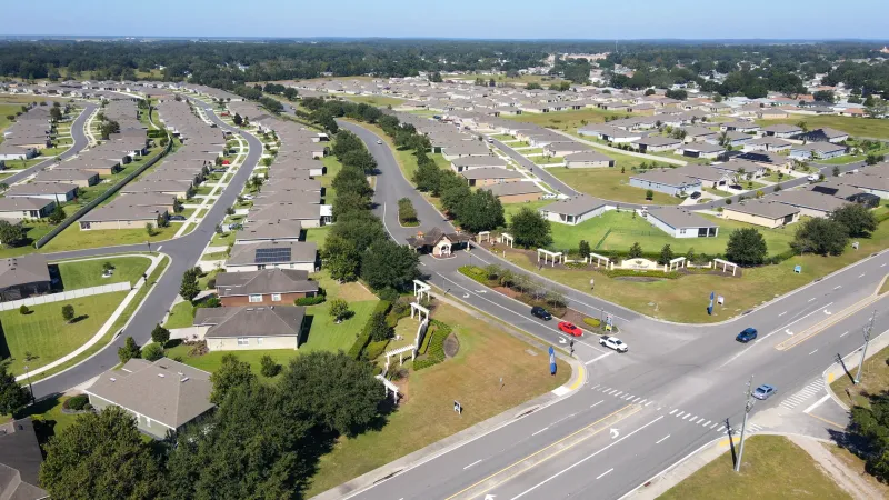 Main road leading to the entrance of JB Ranch along with a birds eye view of the neighborhood.