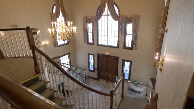Ornate staircase with railings, leading up to the second floor of the clubhouse.
