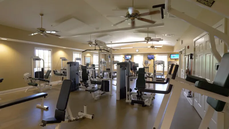 A large gym filled with various types of exercise equipment.
