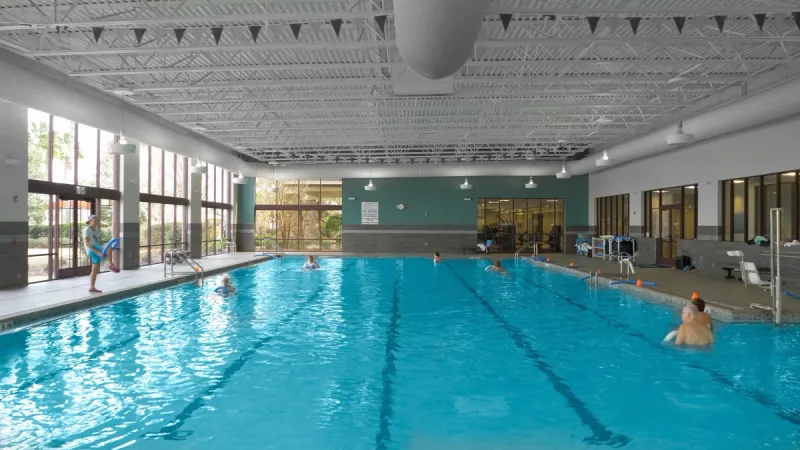 Indoor pool at Stone Creek with lap lanes and large windows to let in natural light.