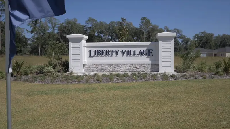 Liberty Village monument sign in Ocala, FL, set against a backdrop of greenery, marking the entrance to this 55+ active adult community.