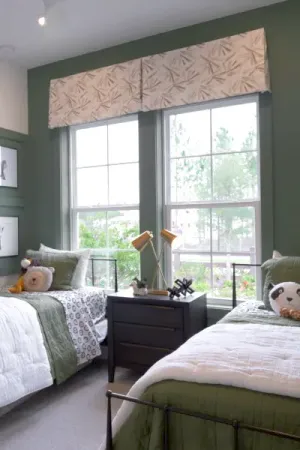 Twin beds on either side of a room set against a large window.