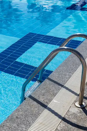Entry ladder into clear blue pool.