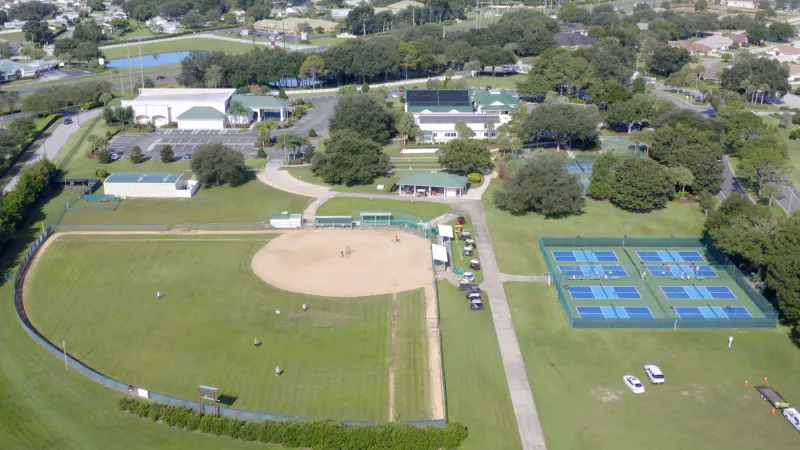 The Stonecrest recreational areas featuring a softball field, pickleball courts, and surrounding buildings.