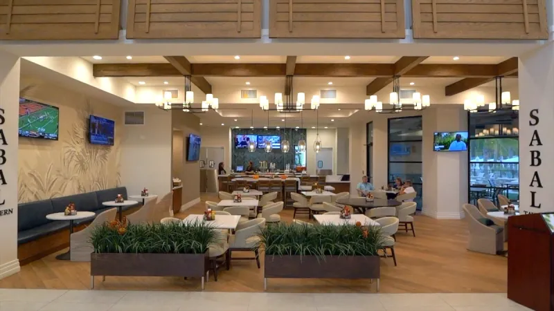 Inside the club at Del Webb Sunbridge, featuring a lounge area with televisions and comfortable seating.