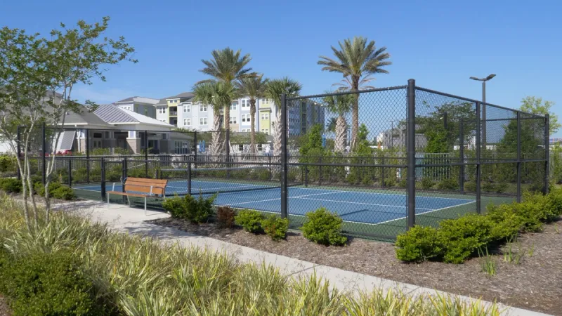 Pickle ball court surrounded by lush landscaping.