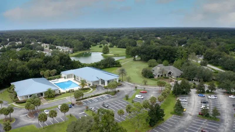 Aerial view of the clubhouse, ponds, and landscaping.