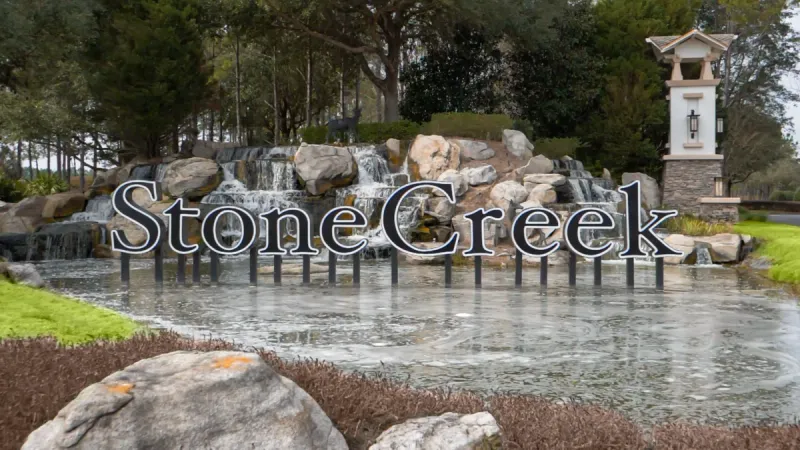 Del Webb Stone Creek monument sign surrounded by a waterfall and pond.