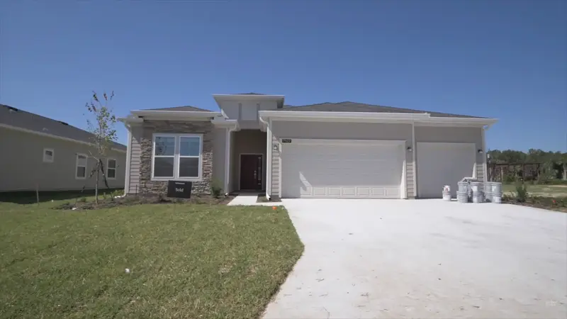 Exterior view of a newly built home in Liberty Village, Ocala, FL, featuring modern design and spacious driveway in this 55+ community.