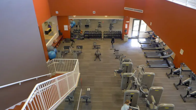 Bird's-eye view of the gym, featuring a variety of weights, exercise balls, and treadmills.