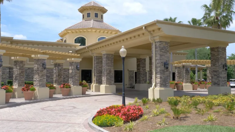 Beautiful clubhouse in The Villages of Citrus Hills featuring stone pillars and meticulous landscaping.