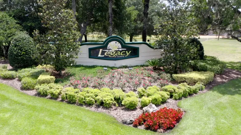 Legacy of Leesburg monument sign with an array of brightly colored plants landscaped around the area.