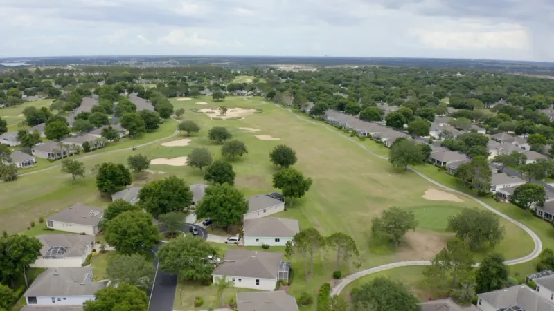 Aerial view of a golf course weaving through Kings Ridge with homes lining the fairways.