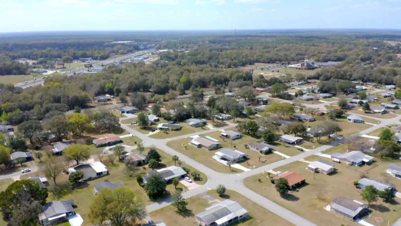 Aerial view of homes with sizable lots along neighborhood streets.