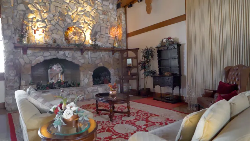 Lounge with couches and large stone fireplace.