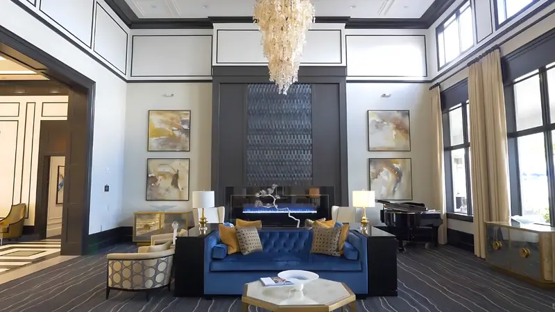 A plush blue sofa in a stylish lobby with large windows and a piano.