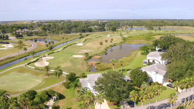 Charming Del Webb Orlando homes positioned alongside the green fairways of the golf course, creating a picturesque neighborhood.