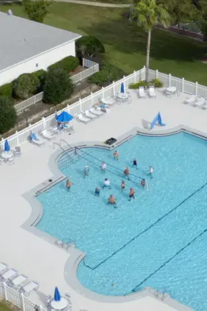 Aquatics clubs meeting in the community pool surrounded by lounge chairs.