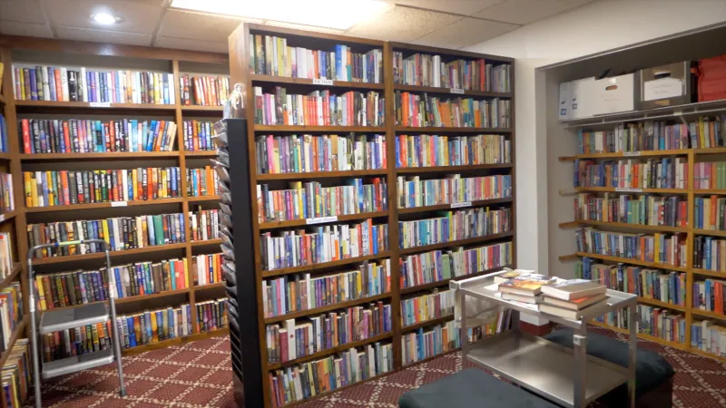 Library with large shelves lined with books.