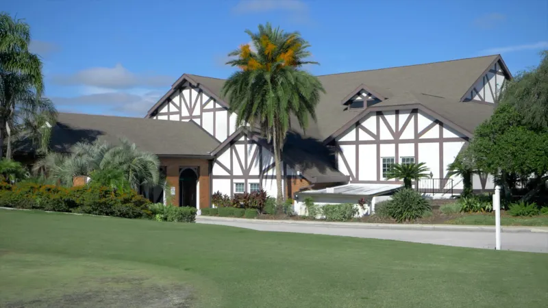 Highland Fairways clubhouse with palm trees in foreground.