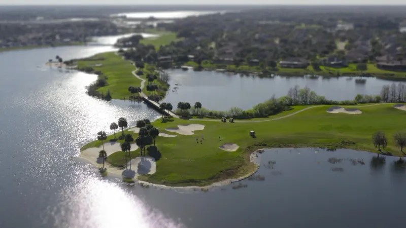 An aerial view of a golf course with lush greens and sparkling lakes, providing an idyllic setting for active retirees.