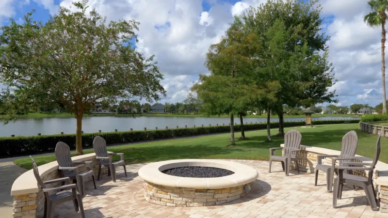 Firepit and seating area near lake.