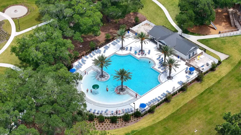 Aerial view of a beautiful pool, providing a bird's-eye perspective of the serene water and lush green surroundings.