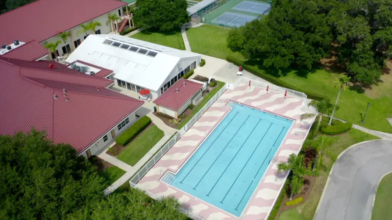 Outdoor pool with lap lanes next to clubhouse.