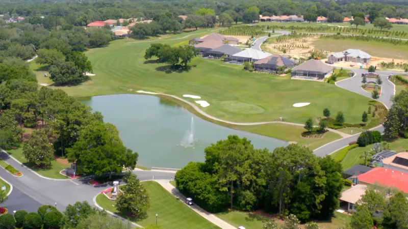 Aerial view of Villages of Citrus Hills golf course with water feature and homes in background.