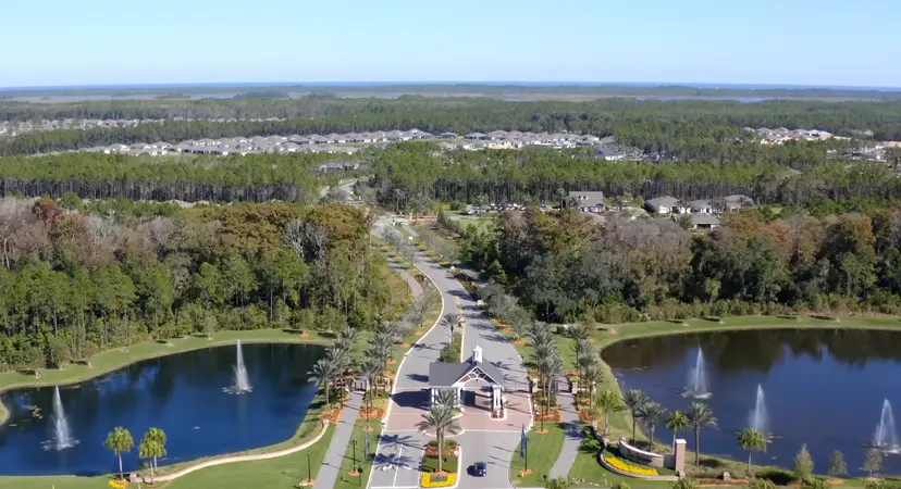 An expansive aerial view showing the entrance to Del Webb Nocatee flanked by serene water features.