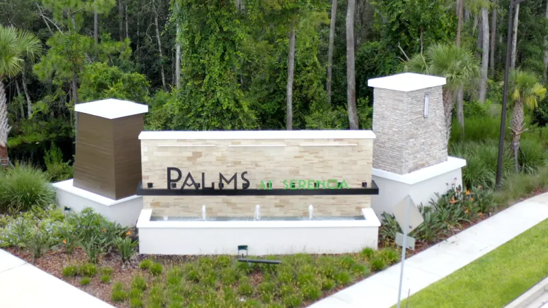 Palms at Serenoa entrance sign surrounded by landscaping at front of community.