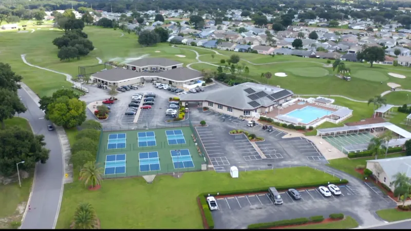 Sandpiper Golf & Country Club sports courts, clubhouse and pool set upon a golf course.