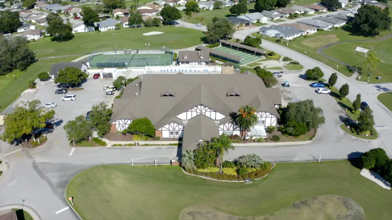 Aerial view of Highland Fairways clubhouse entrance, clubhouse and sports courts.