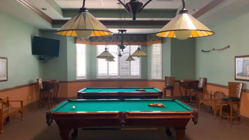 Community billiard room equipped with regulation size pool table and seating areas.