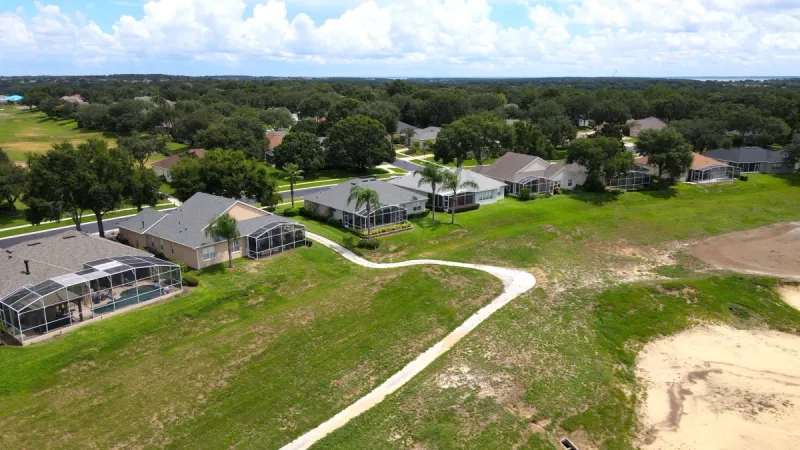 Homes surrounded by lush trees and backing up to golf green.