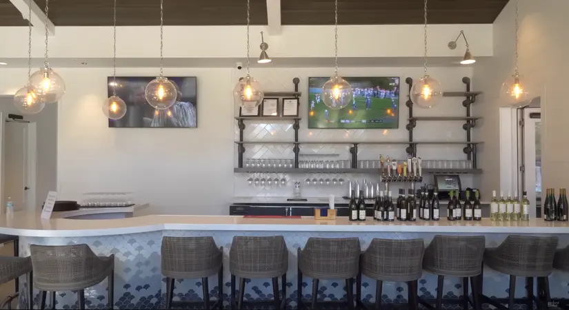 A cozy bar area with stylish pendant lighting and a selection of wines on display, providing a warm social atmosphere at Del Webb Nocatee.
